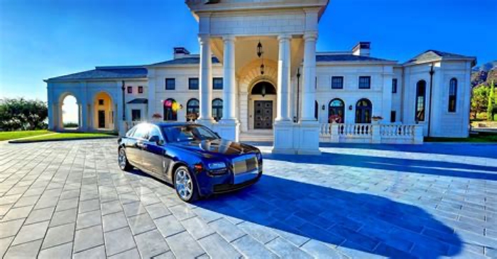 Luxury car parked in front of mansion 