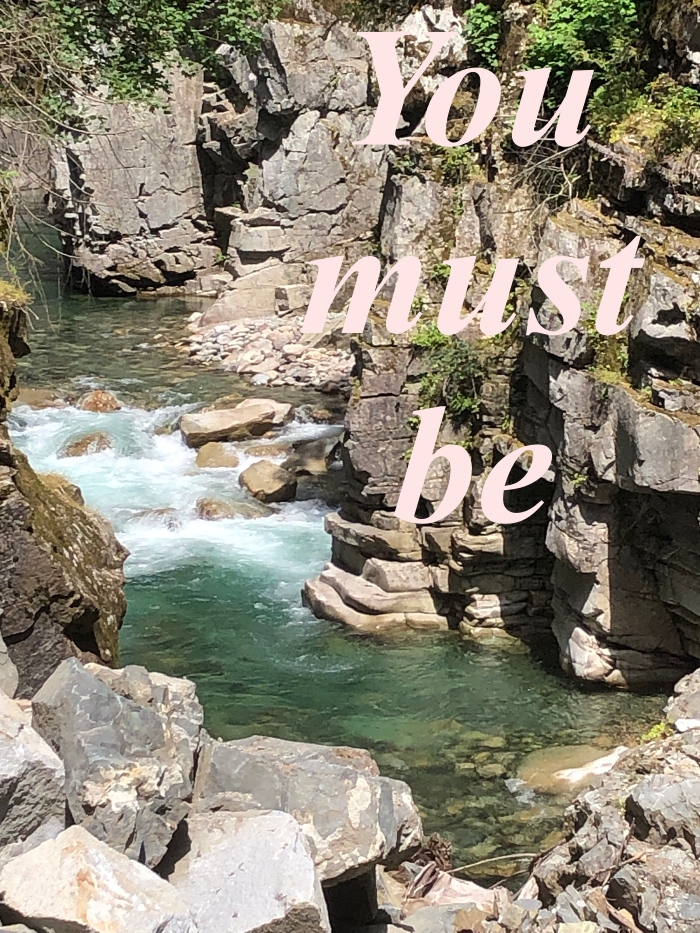 A mountain stream superimposed with "You Must Be"