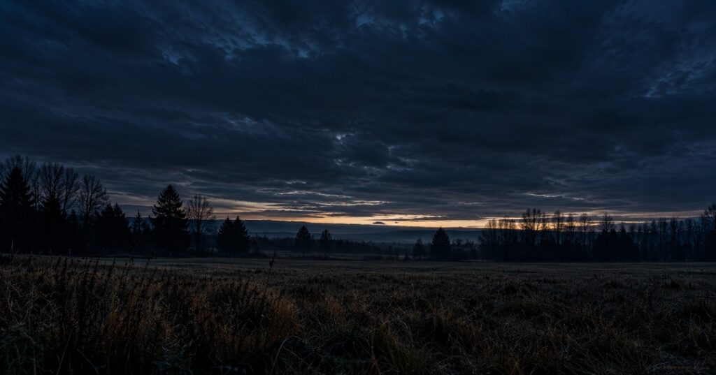 dark morning just before sunrise, a sliver of light visible